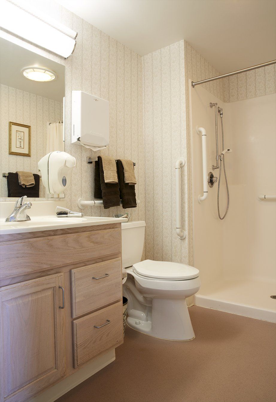 A clean and well-organized bathroom featuring a sink, toilet, and shower.