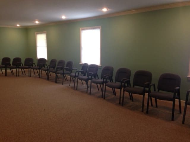 An empty conference room with a row of chairs along the wall.