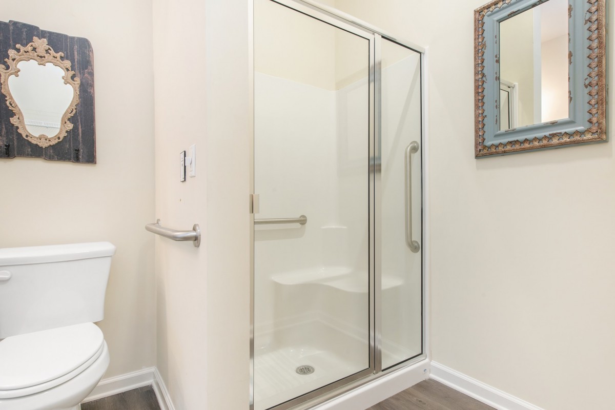 A modern bathroom featuring a glass-enclosed shower stall.