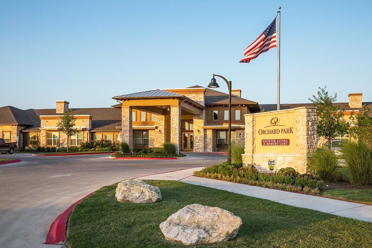 A modern building with a welcoming entrance and an American flag flying in the foreground.