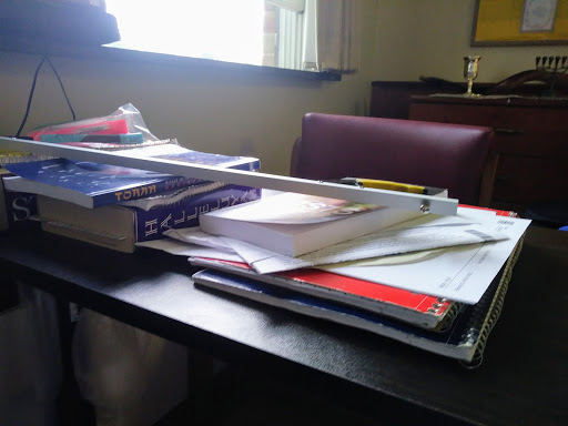 A cluttered desk filled with various study materials and books.
