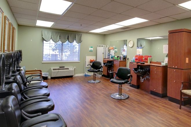 An empty hair salon with styling chairs and mirrors, ready for customers.