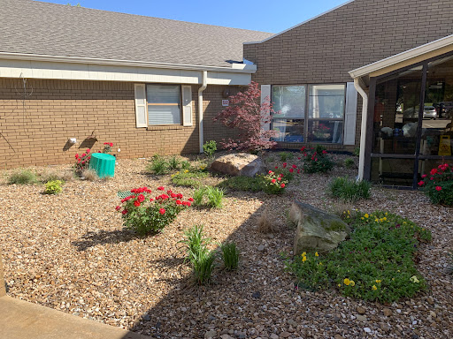 A serene courtyard garden featuring vibrant flowers and lush greenery.