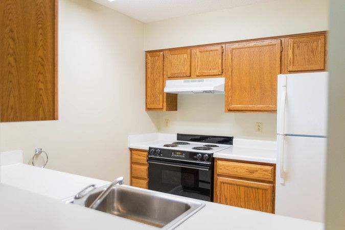 A modern kitchen featuring wooden cabinets and a range of appliances.
