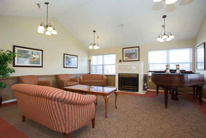 A cozy living room with sofas, a fireplace, and large windows.
