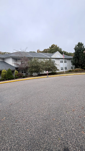 A view of a residential building surrounded by trees on a cloudy day.