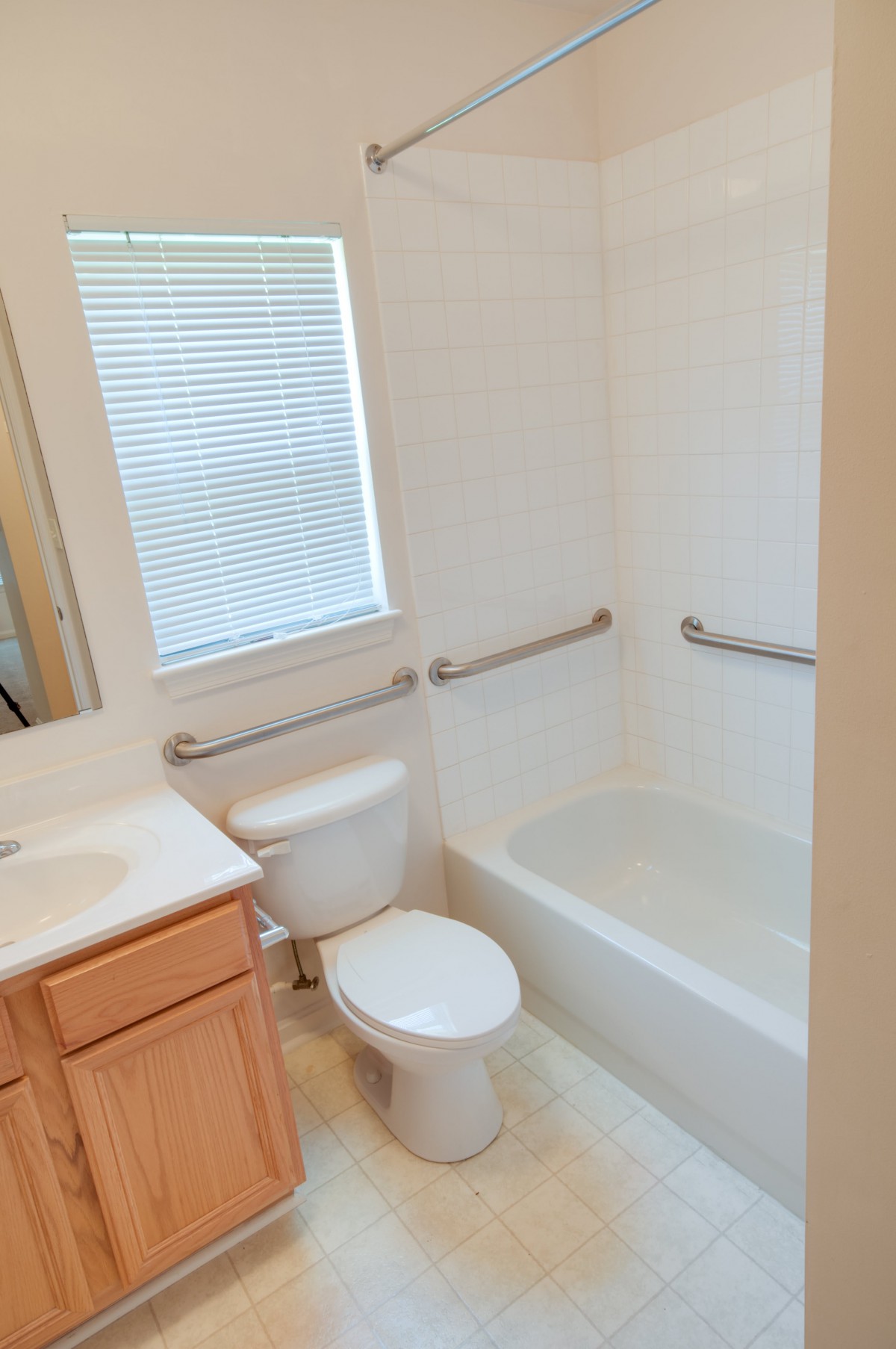 A clean and simple bathroom with a bathtub, toilet, and vanity.