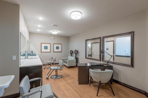 A modern salon interior featuring stylish furniture and ample lighting.