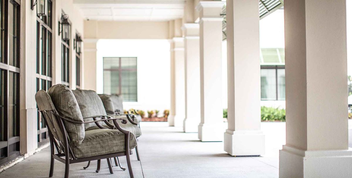 A peaceful corridor with outdoor seating and elegant columns.