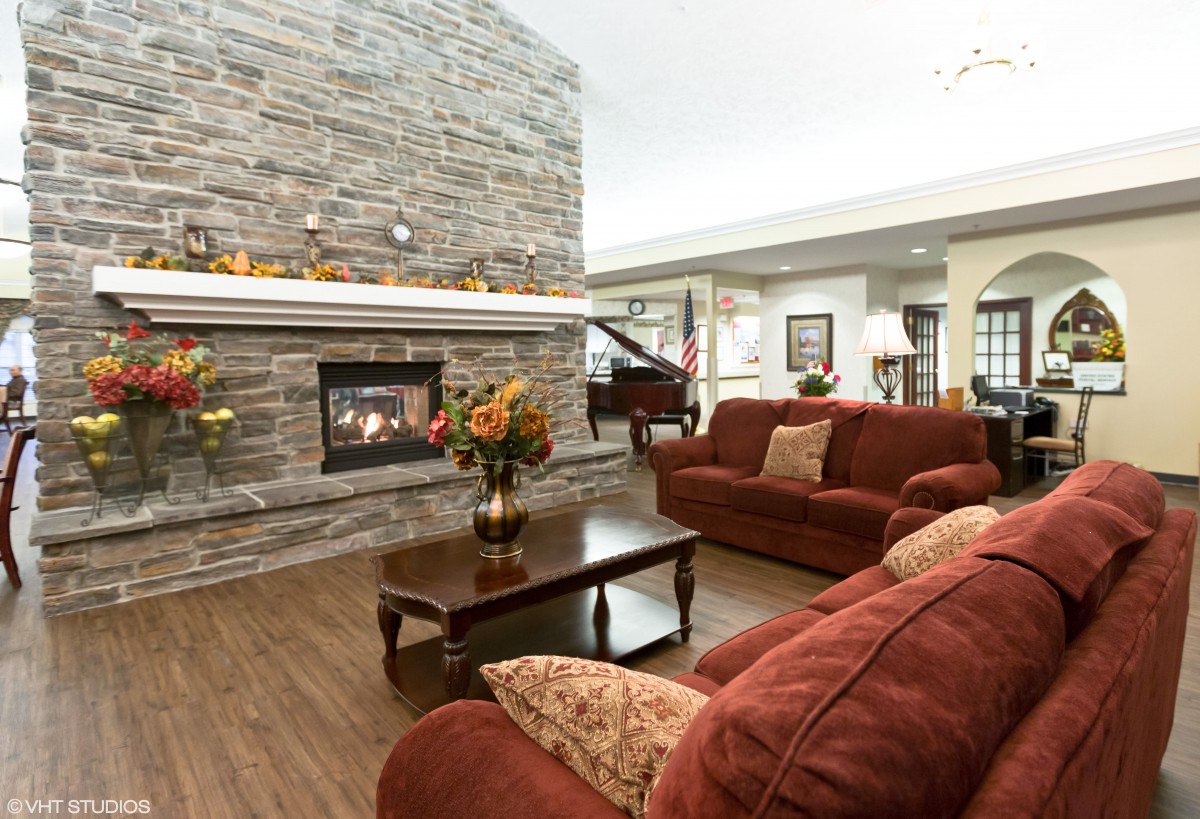 A cozy living room with a stone fireplace and comfortable seating.
