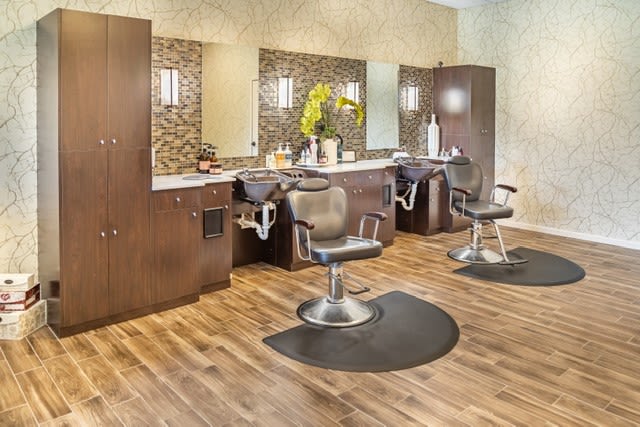 A modern hair salon with styling stations and comfortable chairs.