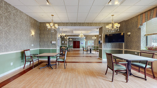 A spacious and elegantly designed dining area featuring tables, chairs, and chandeliers.