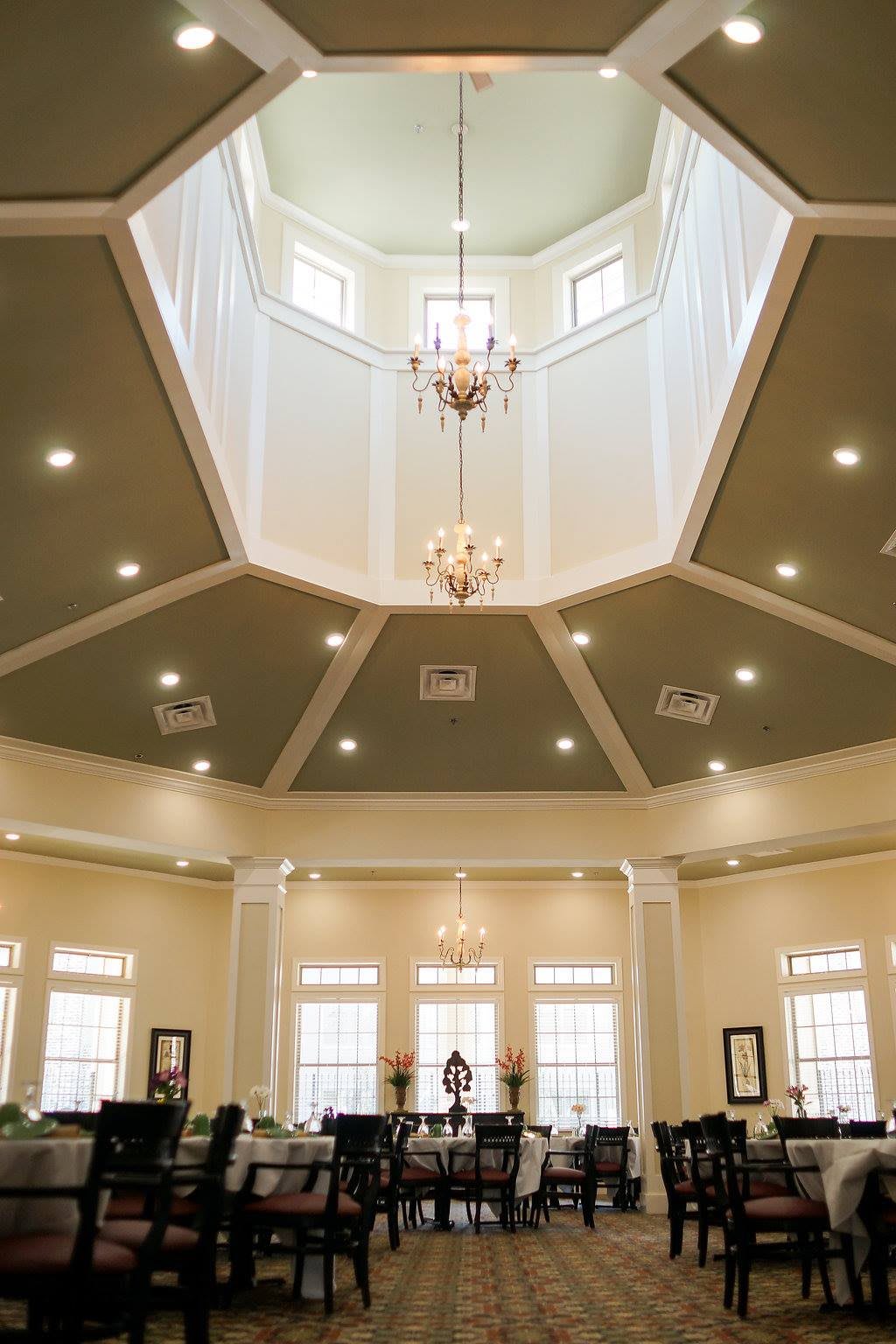 A beautifully designed interior featuring a dome ceiling with chandeliers and ample natural light from the windows.