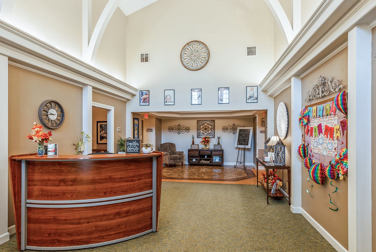 A spacious reception area with a wooden desk, decorative elements, and an arch ceiling.