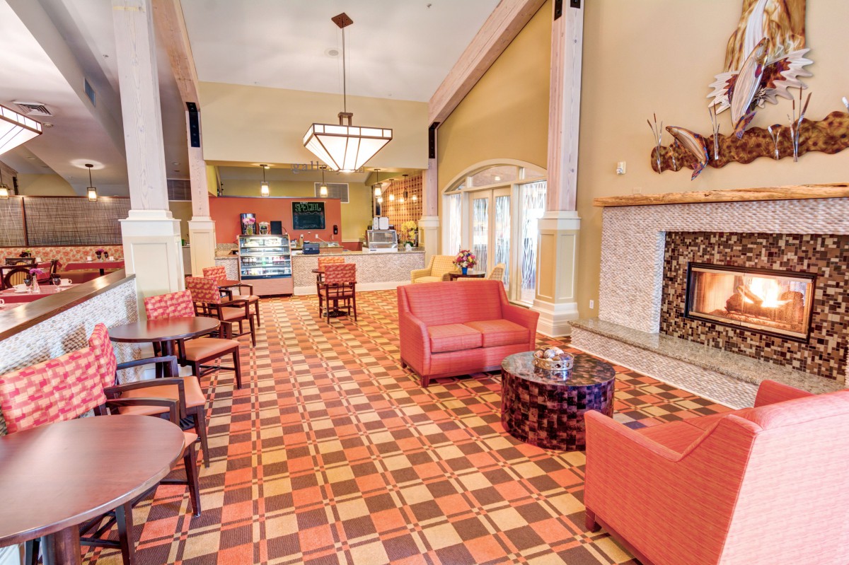 A cozy lounge area with comfortable seating, a fireplace, and decorative lighting.