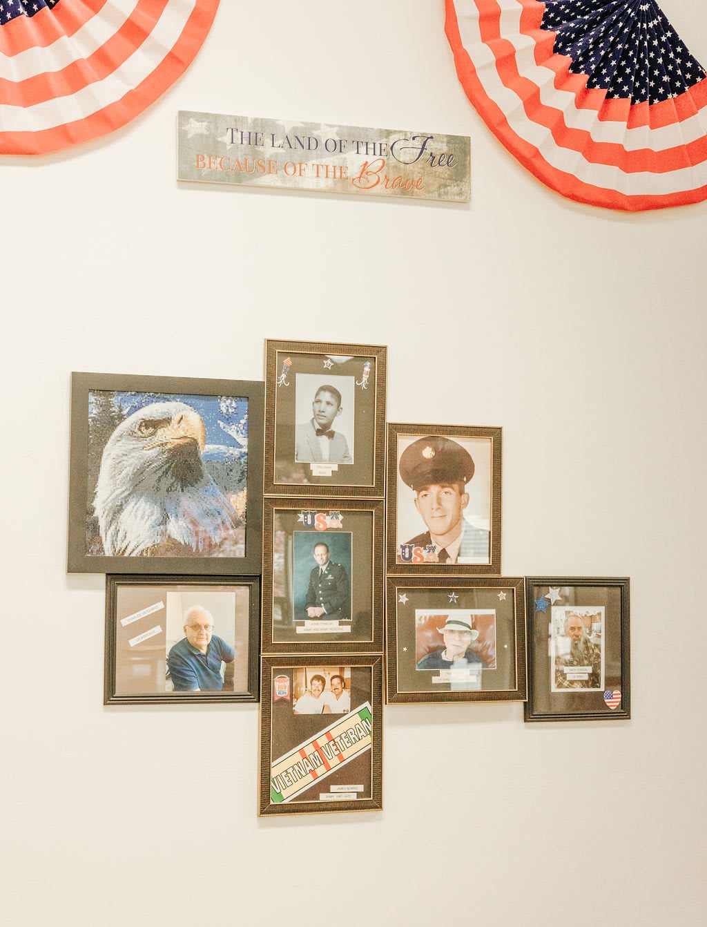 A wall display featuring a collage of framed military-themed photographs, honoring veterans.
