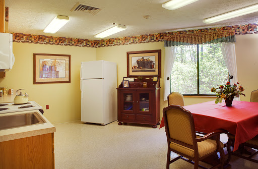 A cozy dining area with a refrigerator, a wooden cabinet, and a table set for meals.
