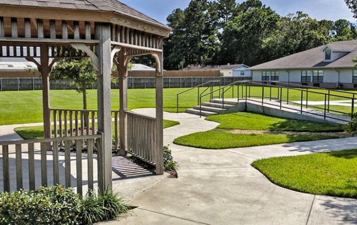 A peaceful garden with a gazebo and winding walkways surrounded by greenery.