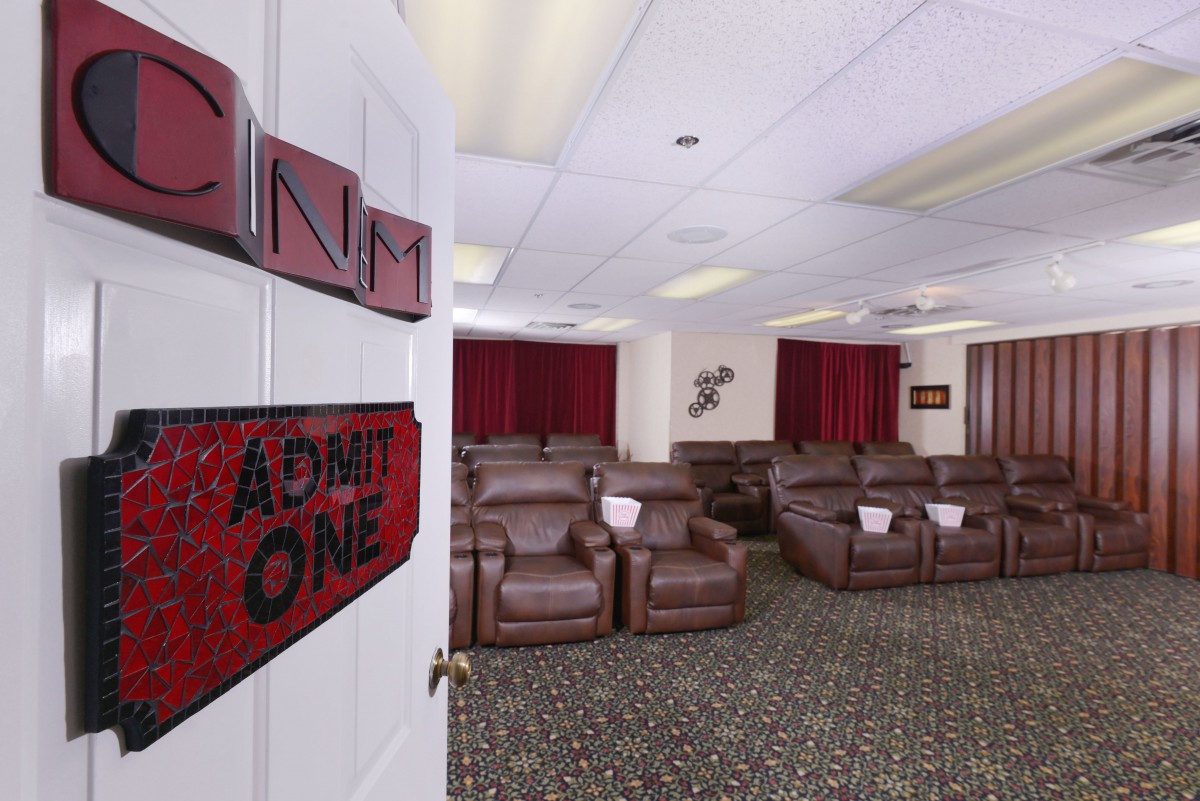 A cozy theater room featuring multiple reclining chairs and red curtains, perfect for watching movies.
