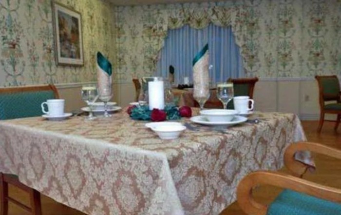 A formal dining table set with patterned tablecloth, glasses, and decorative napkins.