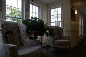 A cozy living room with plush chairs and large windows letting in natural light.