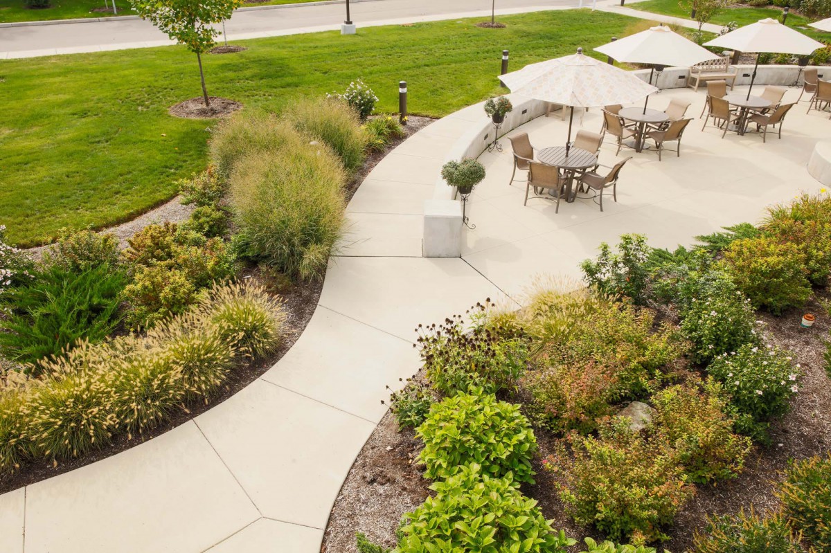 A beautifully landscaped garden with a curved pathway and outdoor seating area.