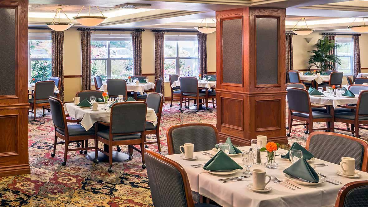 An elegant dining room with neatly arranged tables and chairs.