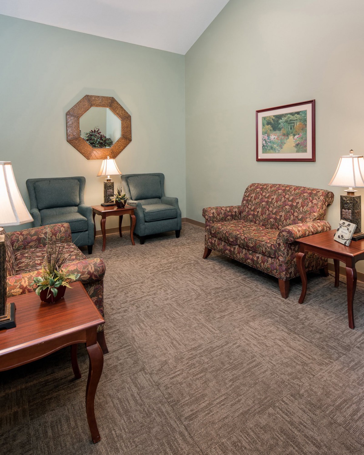 A cozy living room with sofas, armchairs, and decorative lamps.