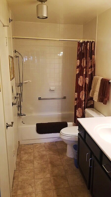 A cozy bathroom with a shower-tub combination and floral shower curtain.