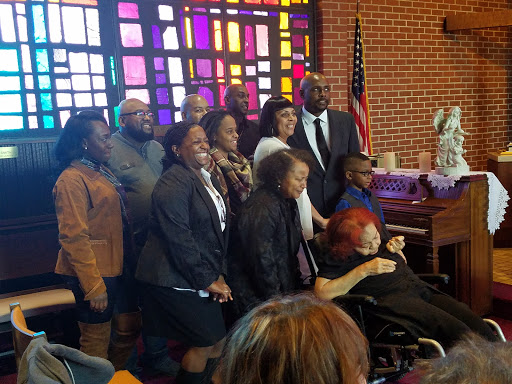 A joyful gathering of community members at a church celebration.