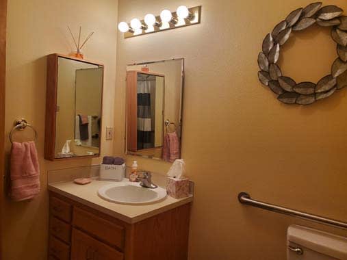 A cozy bathroom with a wooden vanity and decorative elements.