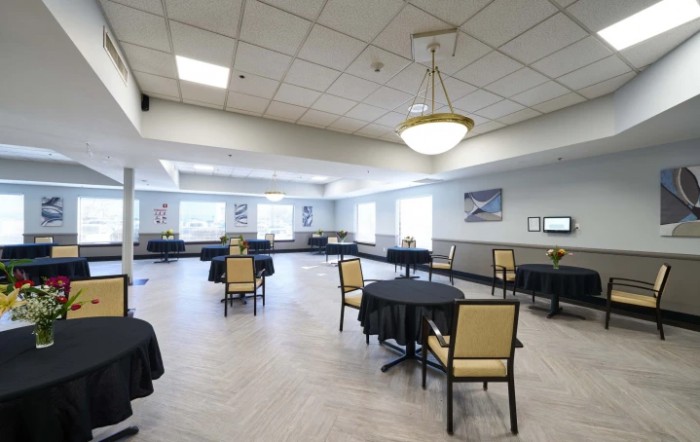 A spacious meeting room with arranged tables and chairs, suitable for conferences.