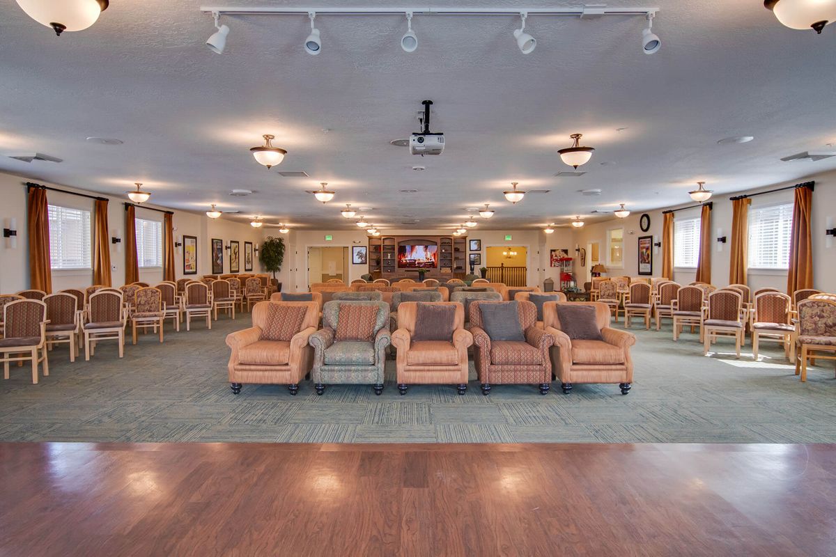A spacious lounge area with rows of comfortable chairs and warm lighting.
