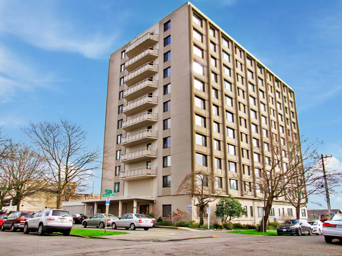 A multi-story apartment building with balconies in an urban setting.