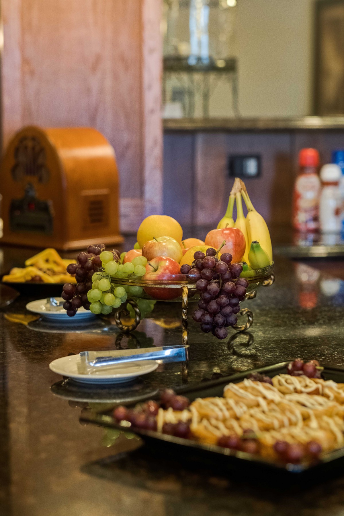 A variety of fruits and snacks are displayed on a kitchen countertop.