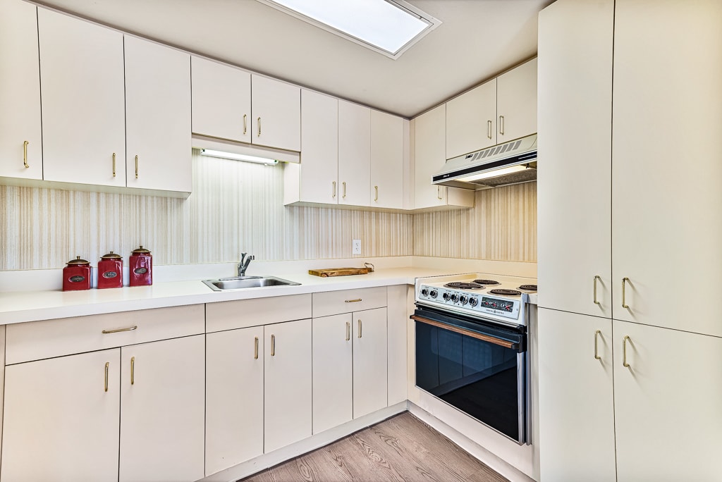 A modern kitchen with white cabinets and a sleek stove.