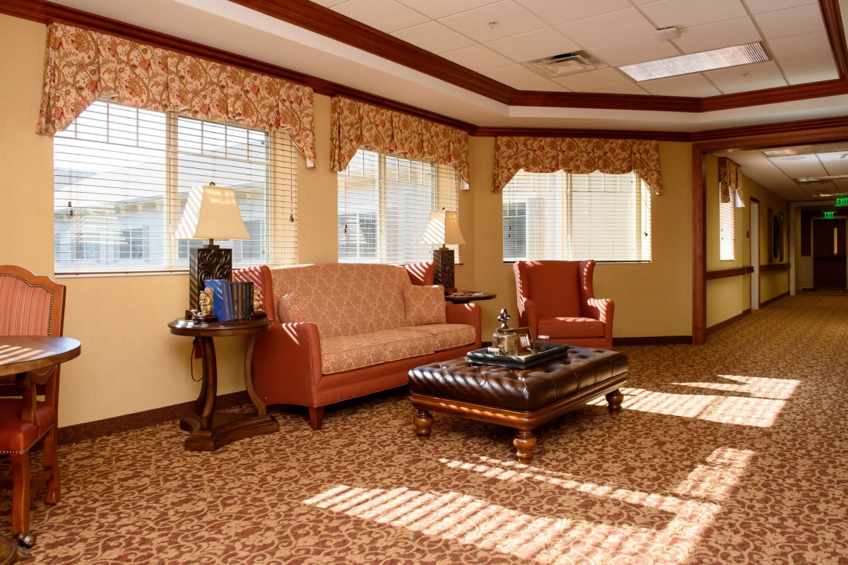 A cozy living room with a sofa, armchair, and coffee table under natural light.