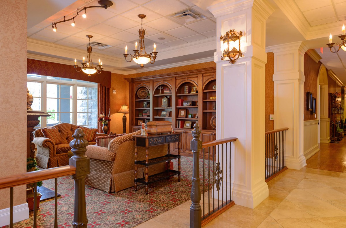 A cozy living room with elegant bookshelves and chandeliers.