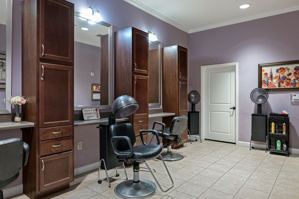 Interior view of a hair salon with styling stations and equipment.