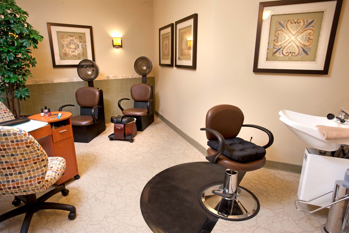 A cozy hair salon interior featuring styling chairs and hair dryers.