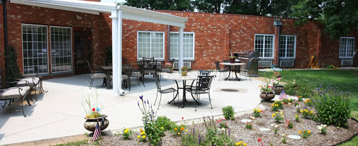 A serene outdoor patio area with tables, chairs, and vibrant flowers.