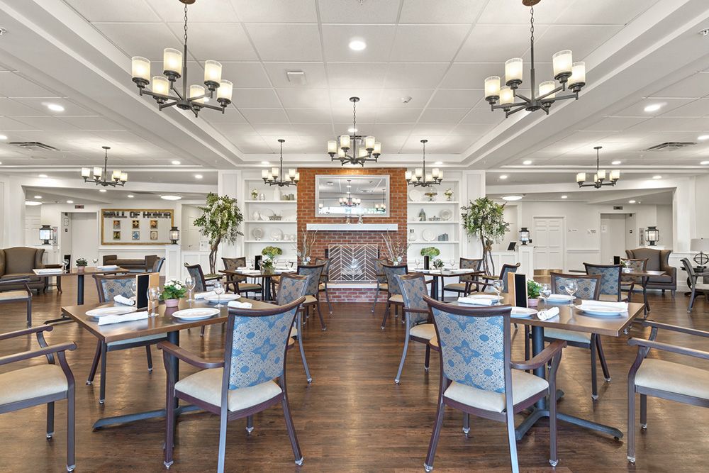 A modern restaurant dining room with elegant chandeliers and neatly arranged tables and chairs.