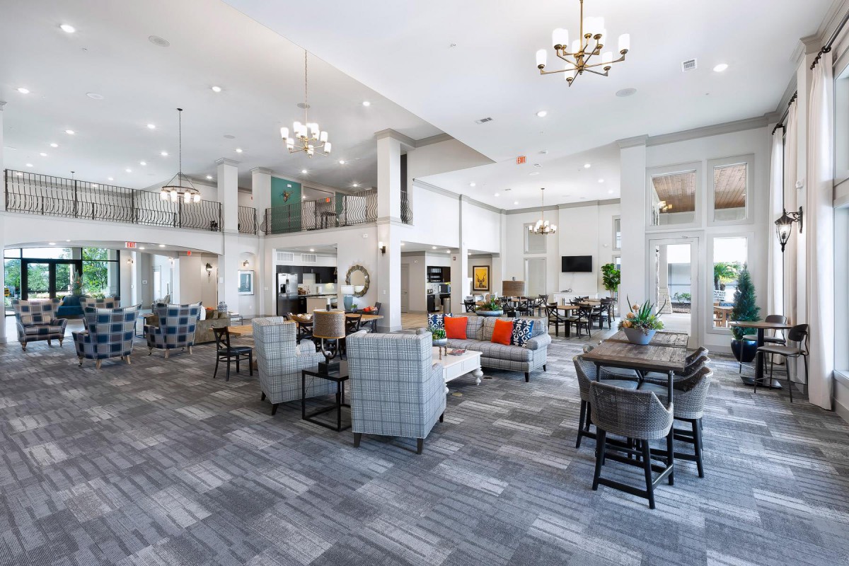 A modern and spacious lobby with elegant furniture and chandeliers.