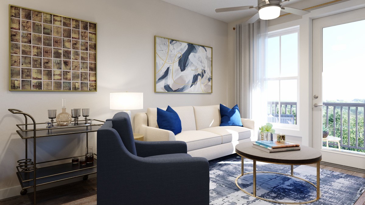 An elegantly decorated living room with a comfortable white sofa, blue cushions, modern artwork, and a stylish armchair.