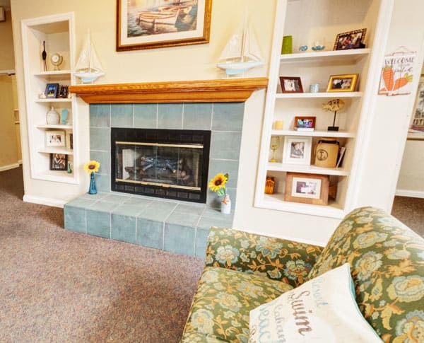 A cozy living room with a fireplace and decorative shelves.