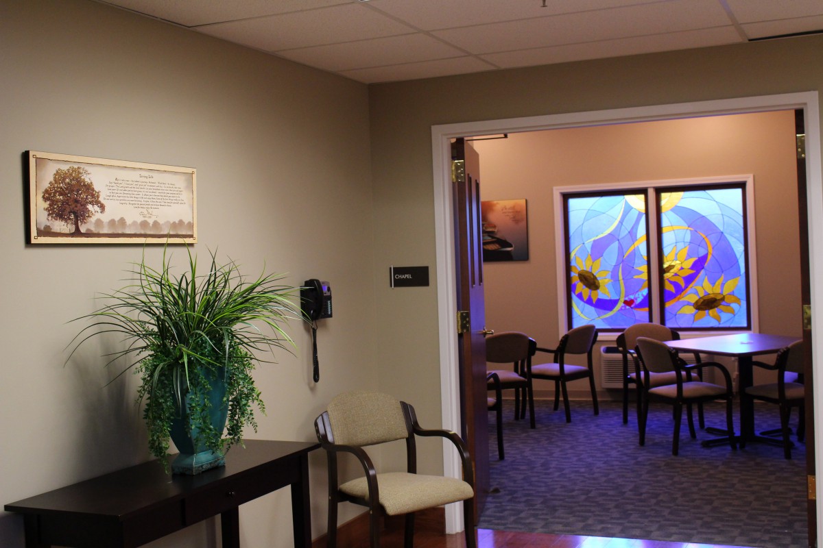 An inviting waiting room with seating, artwork, and a decorative plant.