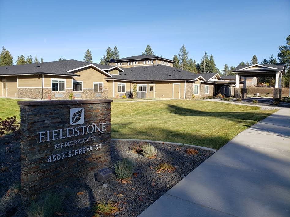 A residential complex with a neatly maintained lawn and a sign reading 'Fieldstone'.