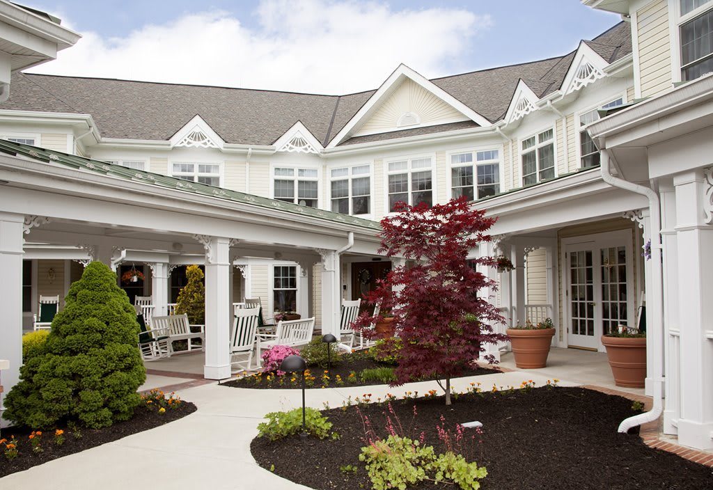 A picturesque courtyard featuring a residential building with charming architectural details and landscaped gardens.