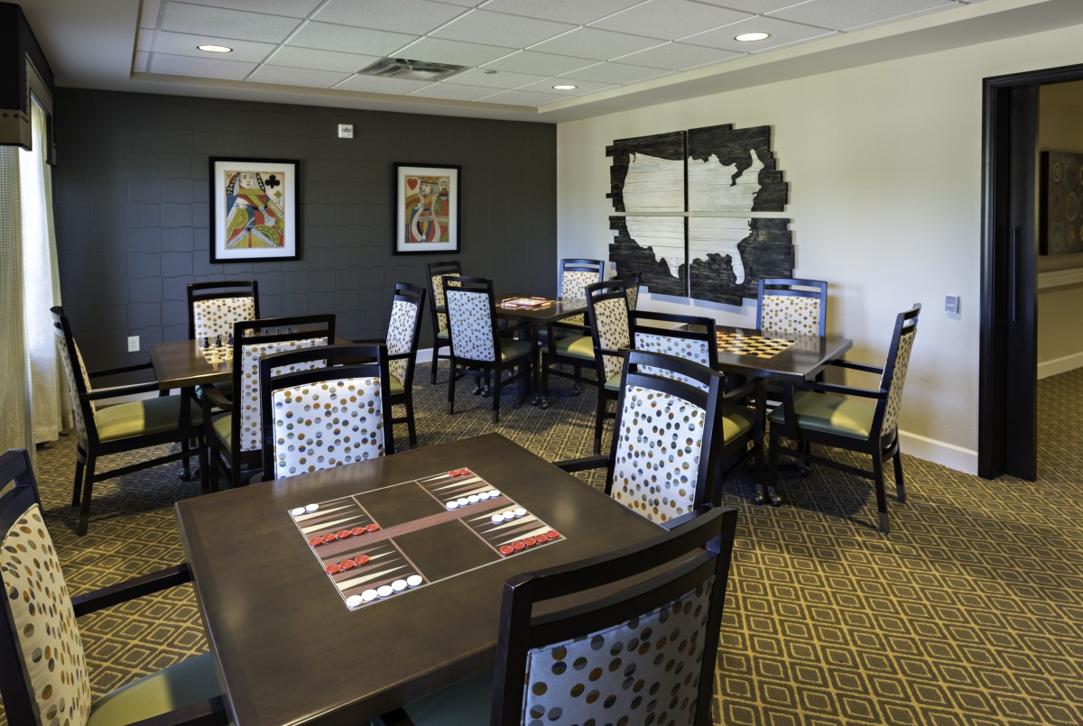 A modern dining area with tables and chairs, decorated with artwork on the walls.
