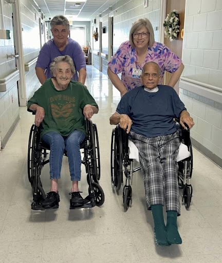 A heartwarming moment in a hospital as elderly individuals enjoy some time with their caregivers.